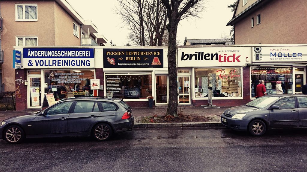 Straßenblick auf das Ladenlokal von Persien Teppichservice Berlin mit Nachbar-Geschäften. Straßenblick auf das Ladenlokal von Persien Teppichservice Berlin mit Nachbar-Geschäften.